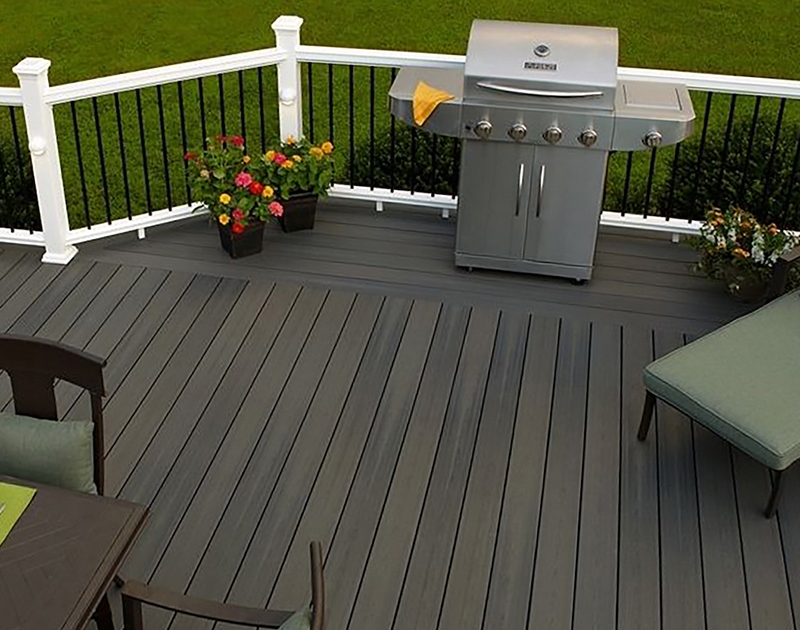 Gray composite deck with grill and outdoor furniture