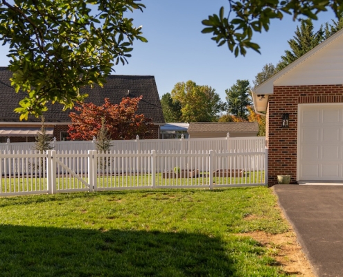 Backyard vinyl fencing next to a detached garage